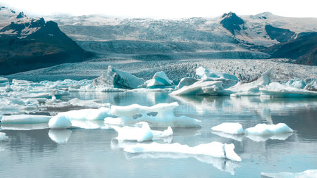 It's a breathtaking glacial lagoon that's dotted with glistening icebergs, creating a mesmerizing scene straight out of a fairy tale. The contrast between the icy blue hues of the icebergs and the black sand beach is truly awe-inspiring. Perfect for adding a touch of icy wonder to your creative projects!の写真素材