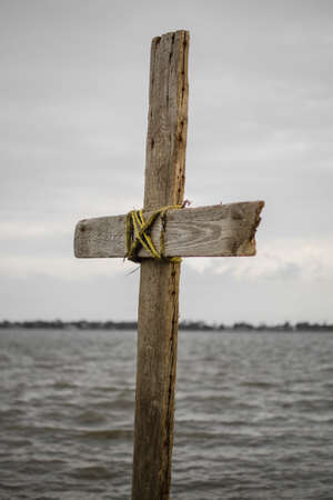 A photo of a cross against the background of a lake!の写真素材