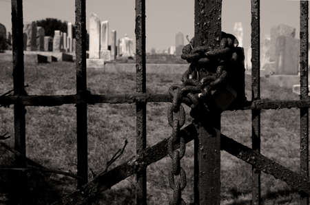 Chained cemetery gate in sepia tonesの写真素材