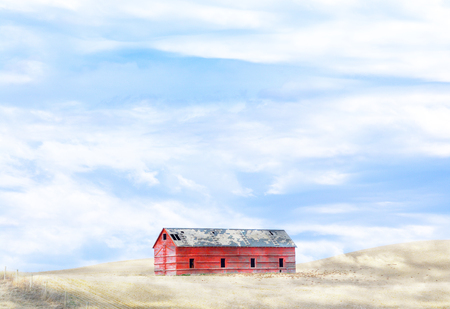 Barn on hill in cloudy fieldの写真素材