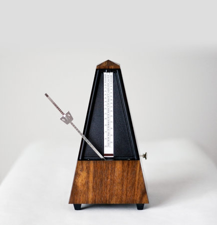 Metronome in action, closeup, isolated and on a plain background