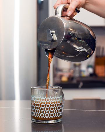 Pouring coffee from a stainless steel French pressの写真素材