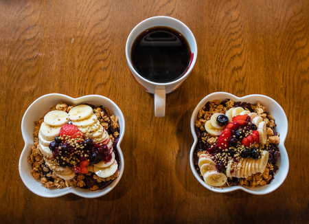 Healthy Acai berry bowls with fruit and granola and black coffee.の写真素材