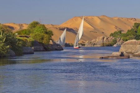 Typical sailing on the Nile  In the background sand hills and blue sky   near Aswan, Egypt   Vertically  の写真素材