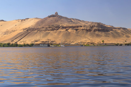 Tombs of the Nobles  Nile boats are anchored at the shore   Aswan, Egypt  