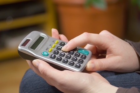 Woman's hands with a calculator. Horizontally.の写真素材