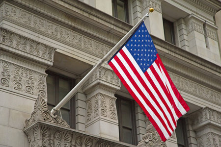 Colour American flag hanging on a pole on the historic building 