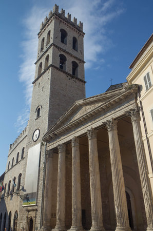 Church with columns at Piazza del Comune in Assisi with tower (Umbria, Italy)の写真素材