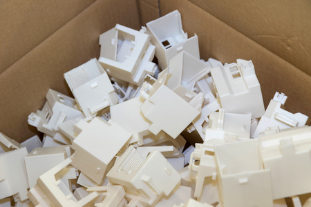Closeup of plastic parts are packed in a cardboard box. All potential trademarks are removed.の写真素材