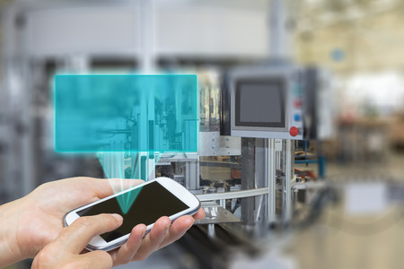Female is using the smart phone Blank transparent rectangle radiates from the screen smart phone. The rectangle is ready for your text. The automatic production line is in the background. The edges of the pictures are deliberately blurred. Female is using the smart phone Blank transparent rectangle radiates from the screen smart phone. The rectangle is ready for your text. The automatic production line is in the background. The edges of the pictures are deliberately blurred.