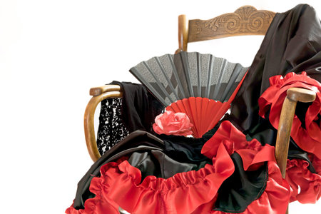 Clothing for Flamenco dance are lying on a vintage wooden chair. All is isolated on the white background.の写真素材