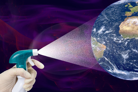 Hand in glove is splashing white spray on planet Earth. Deep purple space is in the background.の写真素材