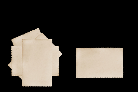Pile of blank vintage photos with jagged edges on the black background. One is horizontally next to them  ready for your text. の写真素材