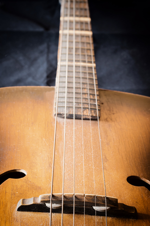 Used guitar closeup. Edited as a vintage photo with dark edges. All potential trademarks are removed.の写真素材