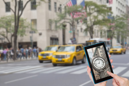 Female finger touching tablet with historic clock in the touchscreen. Intentionally blurred image of...