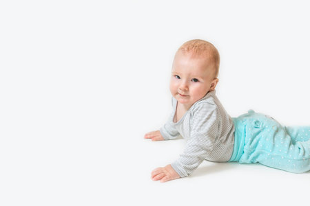 Side view of lying cute little baby boy looking at the camera. All on the white background