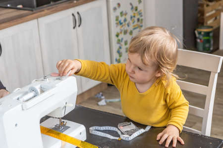 Little boy is helping with sewing at home. Horizontally.の写真素材