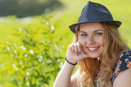 Portrait of beautiful smiling young woman posing in sunny day. Horizontally.