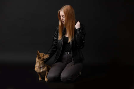 Studio portrait of beautiful young woman together with her dog. Horizontally.の写真素材