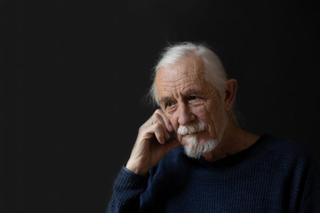 Low key studio portrait of sad beautiful gray hair old man.