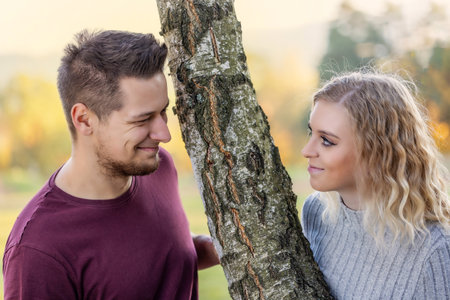 Young loving couple is posing in the autumn park. Horizontally.の写真素材