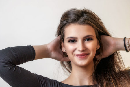 Portrait of smiling happy beautiful girl on light background. closeup. Horizontally.の写真素材
