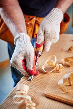 a carpenter using a chisel on a block of woodの写真素材