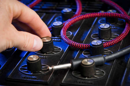 turning a dial on a mixing boardの写真素材