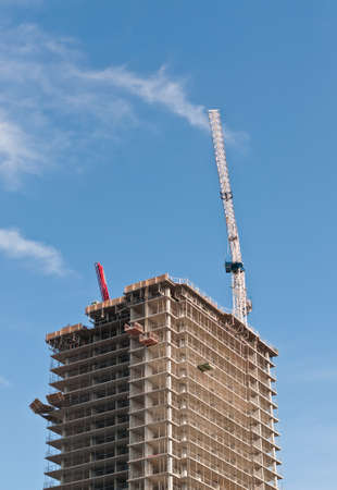 A high rise building under construction with tower crane.の写真素材