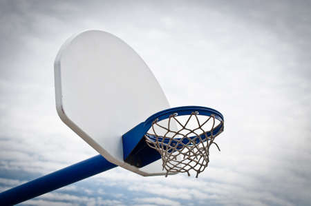 A basketball hoop and backboard in an outdoor playground.の写真素材