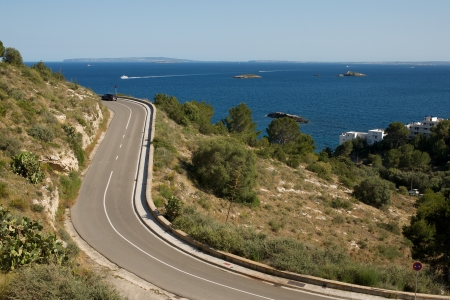 Picture of road turns, with a beautiful sea view and islands in the backgroundの写真素材