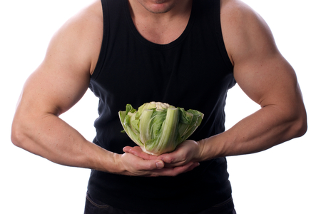 Picture of a fit, muscular arm or body holding vegetables or fruit, on a white, isolated background  Picture of a fit, muscular arm or body holding vegetables or fruit, on a white, isolated backgroundの写真素材