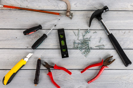 Stock picture of tools and screws on a wooden background