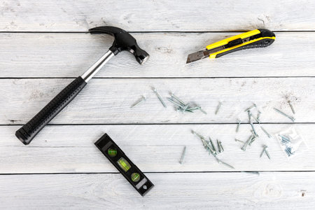 Stock picture of tools and screws on a wooden background