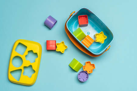 Shape sorting box for toddlers and small kids. Colourful box with plastic puzzles in different shapes and colours, on a coloured backgroundの写真素材