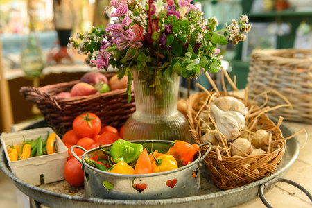 Very rustic sales stall with tomatoes, apples, peppers, and flowers. Big tray at a farm shop with fresh, organic fruit and vegetablesの写真素材