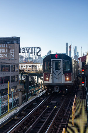 New York, NY / USA - Oct. 14, 2020:  A vertical sunset view of the number 7 subway train pulling...
