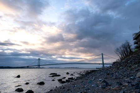 Staten Island, NY - USA - April 10, 2022: Panoramic sunrise view of the iconic Verrazzano-Narrows Bridge, a suspension bridge spanning the Narrows. Seen from Staten Island.のeditorial素材