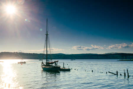 Beacon, NY - USA - June 11, 2022 Horizontal view of a sail boat silhouette at sunset, moored at the Scenic Hudson's Long Dock Park, located on the bank of the Hudson River at Beacon, NY.のeditorial素材