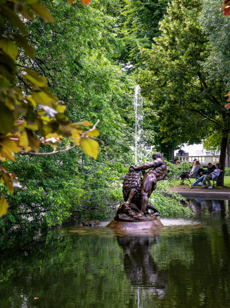 Vienna, AT â June 9, 2023Â  Vertical view of the late Baroque lead sculpture of the Hercules and the Nemean lion fountain in the middle of the historic Burggarten.のeditorial素材