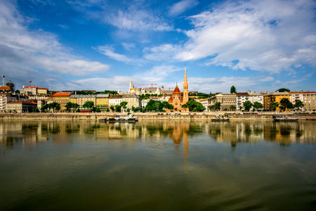 Budapest, HU - June 11, 2023 Wide angle landscape view of the Buda embankment along the Danube River. Highlighting Budapestâs SzilÃ¡gyi DezsÅ Square Reformed Church and Fisherman's Bastion.のeditorial素材