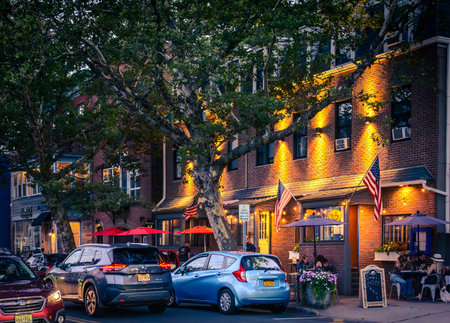 Piermont, NY - US - Aug 20, 2023 Summer landscape view of people enjoying the nightlight of Piermont Avenue's restaurants, shops and bars.のeditorial素材