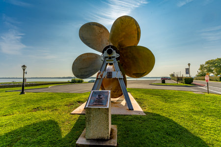 Bronx, NY - US - Aug 24, 2024 The propeller of the S.S. United States is a towering, five-blade artifact at Fort Schuyler, honoring maritime history with its backdrop of serene waters and a clear sky.のeditorial素材
