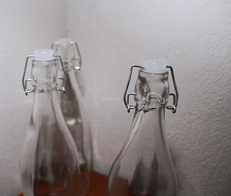 Three Bottles on a nightstand in the corner of a room against a textured wallの写真素材