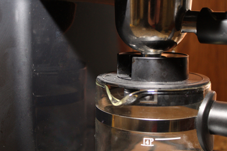 close up of a black and chrome espresso machine with glass underneathの写真素材