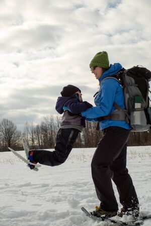 Mom and Young Boy Swinging With Snowshoes6の写真素材