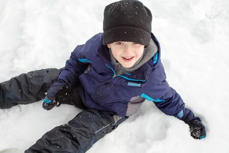 Winter Boy Sitting In Snow From Aboveの写真素材