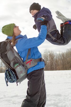 Mom and Young Boy Swinging With Snowshoes0の写真素材