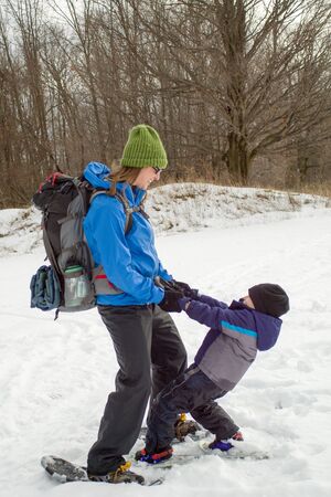 Mom and Young Boy Swinging With Snowshoes1の写真素材