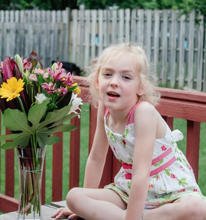 Young Girl in Colorful Dress Smelling Bouquet of Flowers in Springtime10の写真素材